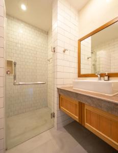 拉差汶里Navela Hotel & Convention的一间带水槽和镜子的浴室