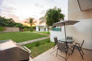 巴亚尔塔港Casa Amor的庭院配有桌椅和遮阳伞。