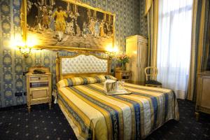 威尼斯诺埃米酒店的卧室配有一张床,墙上挂有绘画作品