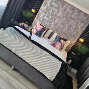 伯明翰Luxury 9ine SUPER BEAUTIFUL JACUZZI APARTMENT WITH BALCONY的一间卧室配有一张带枕头的大床