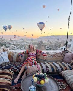 格雷梅奥利弗洞穴酒店的坐在天上带气球的沙发上的女人