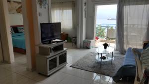 利马索尔Sea Front & City Center, Amazing Sea View的客厅配有电视、沙发和桌子