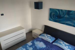 罗马Barzo Apartment的卧室配有蓝色和白色的床和梳妆台。
