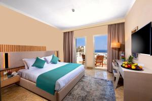 赫尔格达Zen Resort Sahl Hasheesh by TBH Hotels的酒店客房配有一张床和一张书桌及一台电视