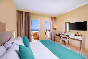 赫尔格达Zen Resort Sahl Hasheesh by TBH Hotels的酒店客房配有一张床和一张书桌及一台电视