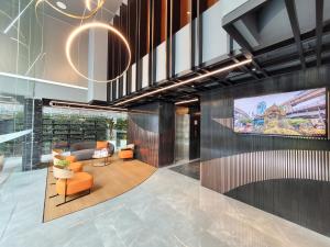 曼谷康帕斯酒店集团素坤逸13巷娜娜柑橘酒店的大堂配有沙发和墙上的电视
