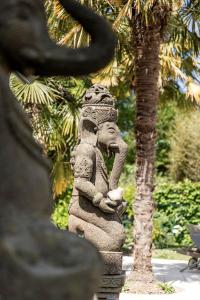 坎佩尔Manoir des Indes, The Originals Relais (Relais du Silence)的站在一棵树旁的大象雕像