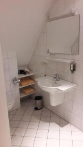 LastrupLandhaus Lastrup的白色的浴室设有水槽和镜子