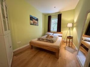 莱希林根Gartenblick的一间设有床铺的卧室,位于一个拥有绿色墙壁的房间
