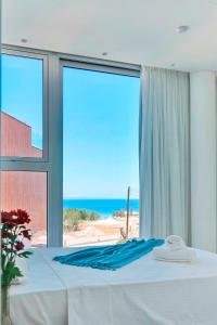 帕拉利米尼Sunrise Seaview Villas - Camelia的一间卧室设有一张床,享有海景