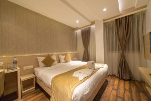 贝尔高姆Hotel Samudra的一间设有大床和窗户的酒店客房