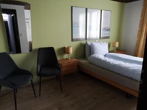维尔德豪斯Gasthaus Friedegg的一间卧室配有一张带两把椅子和镜子的床