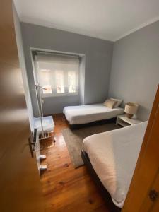 里斯本贝勒姆阿罗贾公寓的一间小卧室,配有两张床和窗户