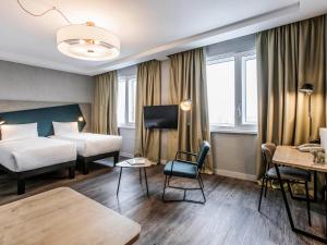 基辅Adagio Kyiv Beresteiska的酒店客房设有两张床和一张桌子。