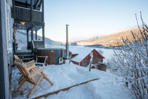 FavangStamp and sauna! Small farm with fantastic view!的一个带长凳和热水浴池的雪覆盖庭院