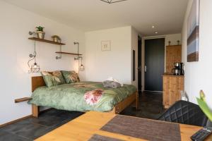 登霍伦Johanneshoeve - de mooiste plek op Texel的卧室配有一张床铺,位于带桌子的房间