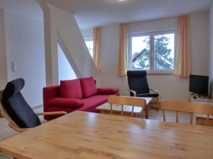 HirschburgFerienwohnung NH14的客厅配有红色的沙发和椅子