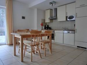 HirschburgFerienwohnung NH10的厨房配有木桌和椅子