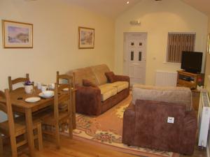 LaxeyPinfold Holiday Cottage的客厅配有沙发和桌子