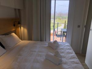 萨维利亚诺Green Village - Sirenetta的一间卧室配有带毛巾的床