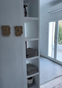 伊斯纳哈尔Casa Olivo的一间设有白色书架、毛巾和窗户的客房