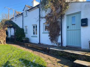克里克豪厄尔Cosy Country Cottage; Brecon Beacons的街上的白色房子,有绿门