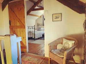 克里克豪厄尔Cosy Country Cottage; Brecon Beacons的一间带柳条椅的客厅和一间卧室