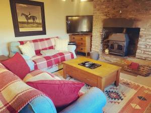 克里克豪厄尔Cosy Country Cottage; Brecon Beacons的带沙发和壁炉的客厅