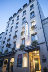 巴黎丹弗特 - 蒙帕纳斯酒店的一座白色的建筑,里面装有窗户和植物
