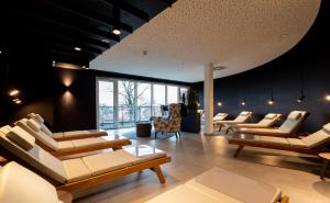 梅彭VIA PLAZA Hotel Meppen的一间客厅,客厅配有沙发和椅子