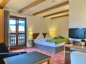 巴特维塞Sonnhof Apartments Tegernsee - zentral und perfekt für Urlaub & Arbeit的酒店客房,配有床和电视