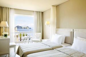 科孚镇Mon Repos Palace - Adults Only的酒店客房设有一张床和一个大窗户