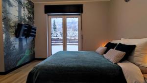 什切尔克Apartament Olimpijska 54 z prywatnym jacuzzi的一间卧室设有一张床和一个滑动玻璃门