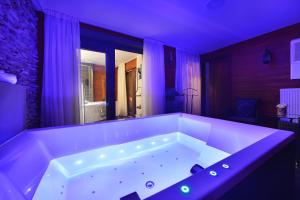 捷克利帕Hotel Morris Premium Collection的紫色照明的房间内的大型白色浴缸