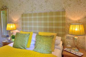凯珀尔克里格Bryn Tyrch Rooms的一间卧室配有一张带黄色枕头的床和两盏灯。
