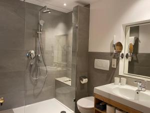 巴特维塞Sonnhof Apartments Tegernsee - zentral und perfekt für Urlaub & Arbeit的带淋浴、卫生间和盥洗盆的浴室