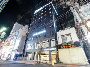 横滨HOTEL LiVEMAX Yokohama Motomachi Ekimae的城市街道上的一个大型建筑