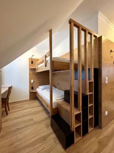 圣卡瑟林阿哈Gasthof zur Post的客房设有两张双层床和一张书桌。