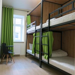 弗罗茨瓦夫FOKA Hostel的客房设有两张双层床和绿色窗帘