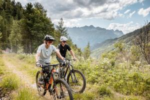 索尔登Hotel Silbertal的两人骑着自行车在山间小径上