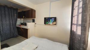 KidonoRuth's Haven的小房间设有一张床和墙上的电视