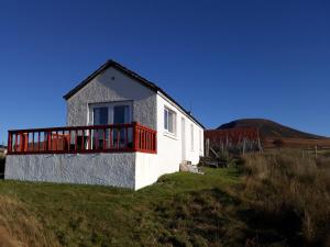 KinbraceGarvault House的山丘上带红色阳台的白色房屋