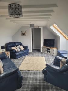 斯特罗姆内斯Lindisfarne Bed & Breakfast的客厅配有蓝色的沙发和电视