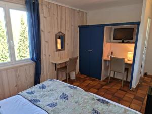 乌韦兹河畔莫朗Logis Hôtels Le Saint Marc的一间卧室配有一张床、一张书桌和一台电视