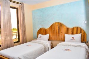 NyahururuBreeze Hotel Nyahururu的带窗户的客房内的两张床