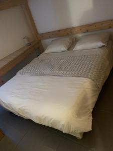 沃雅尼Appartement Matiski的一张带白色床单和枕头的床