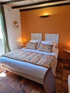 乌韦兹河畔莫朗Logis Hôtels Le Saint Marc的一间卧室配有一张带橙色墙壁的大床