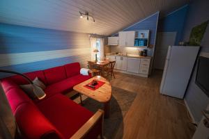 弗勒Førde Gjestehus og Camping的一间带红色沙发的客厅和一间厨房