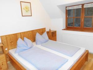 伊布斯河畔格施特灵Ferienhaus Soghäusl的一间卧室配有一张带蓝色枕头的床