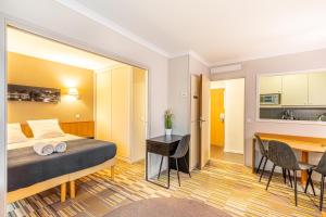 伊西莱穆利诺Paris Expo Apart Hotel Porte de Versailles - Parking的酒店客房配有一张床铺和一张桌子。